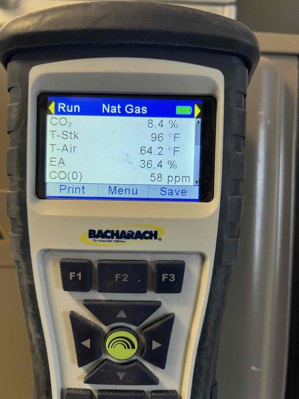 Responded to no-heat service call for 10+ year old furnace located in laundry room. Performed complete diagnostic testing using digital multimeter and Bacharach gas analyzer, which revealed CO levels at 58 ppm and excess air at 36.4%. Resolved issue causing unit to blow cold air and verified proper combustion parameters with stack temperature at 96.2°F.