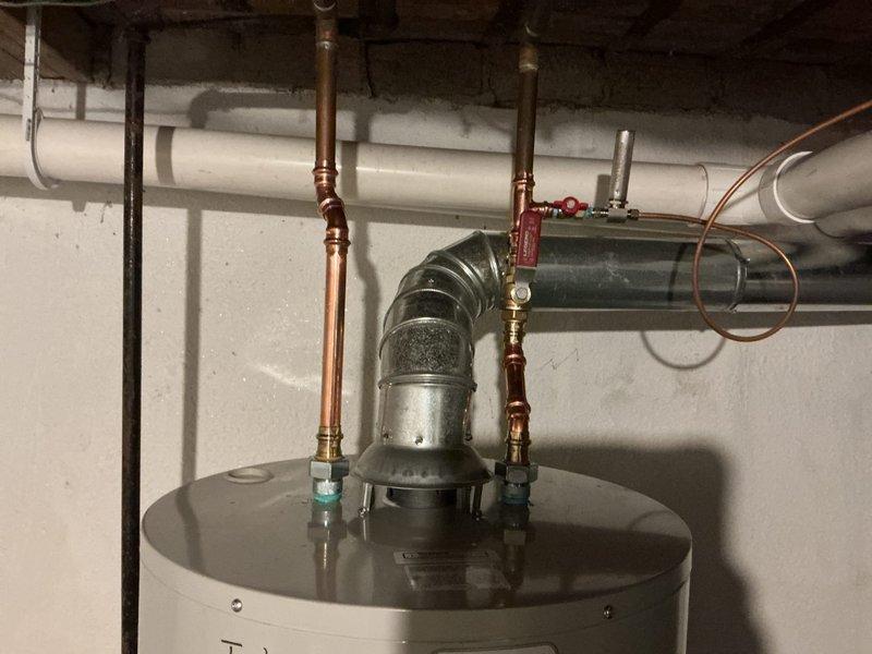 Successfully installed a 50-gallon Bradford White water heater with proper connections to existing copper and PVC piping. Installation included a drip pan with alarm system for leak protection. All supply lines, vent pipe, and connection valves were properly fitted and secured according to manufacturer specifications.