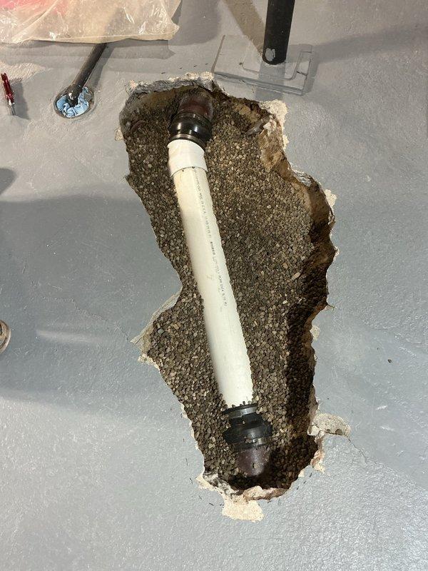 Performed camera inspection and sold repair estimate for floor break issue. Investigation revealed severely corroded metal pipe requiring replacement, with excavation exposing significant deterioration and oxidation. Documented damaged concrete/mortar surface with new PVC pipe installation including metal fittings and connectors.