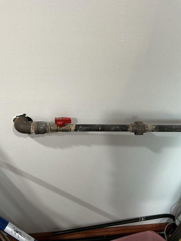 Completed installation of water line and gas line connections for residential washer and dryer. Installed shut-off valve on existing galvanized steel water supply pipe and connected yellow flexible gas connector to wall-mounted gas valve. All connections were secured and tested for proper operation with no leaks detected.