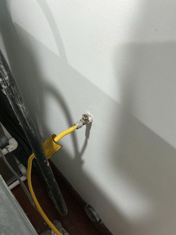 Completed installation of water line and gas line connections for residential washer and dryer. Installed shut-off valve on existing galvanized steel water supply pipe and connected yellow flexible gas connector to wall-mounted gas valve. All connections were secured and tested for proper operation with no leaks detected.