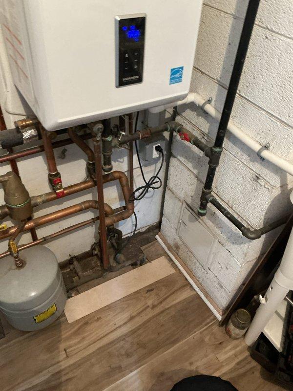 Completed Gold Boiler Inspection on Navien hot water combination boiler/water heater system. Unit is under 10 years old, properly installed with appropriate copper piping connections, expansion tank, and functional digital control panel. System is operating normally with no issues detected.