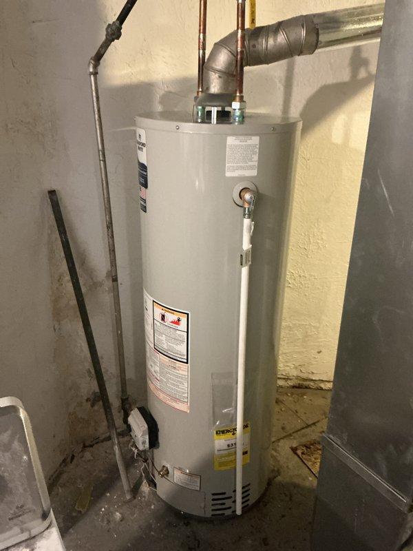 Successfully installed a 40-gallon water heater in basement utility area. Completed standard reconnection of copper supply lines, metal vent pipe with insulation, and drainage pipe. Installation includes all necessary safety components and proper ventilation per manufacturer specifications.