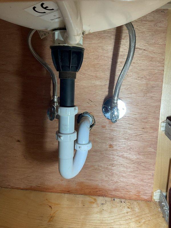 Addressed leaking bathroom faucet at the base by replacing the fixture and associated supply lines. Removed existing P-trap assembly and installed new PVC piping under the sink to remediate water damage that had caused significant wall deterioration behind the fixture. All connections were tested and verified leak-free upon completion.