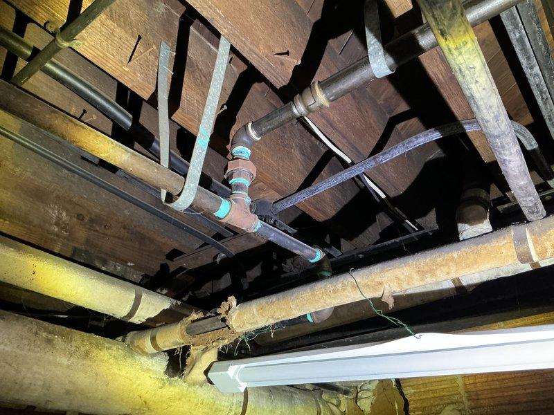 Responded to a service call for gas leak investigation after DTE detection. Performed comprehensive pressure testing of gas lines in basement utility area, identifying two separate leak points in the copper gas piping system. Inspected exposed plumbing infrastructure with particular attention to pipe joints and connections where turquoise/teal markings were present on the aged copper lines.