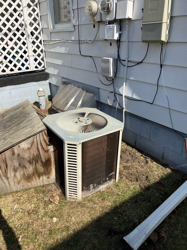 Inspected 20+ year old natural gas furnace located in crawl space under house; unit is currently operational but approaching end of service life. Exterior assessment revealed weathered York AC unit with significant rust on fan cover, dirt/residue buildup on coil cover, and deteriorated condition consistent with age. Provided replacement options for complete system upgrade to improve efficiency and reliability.