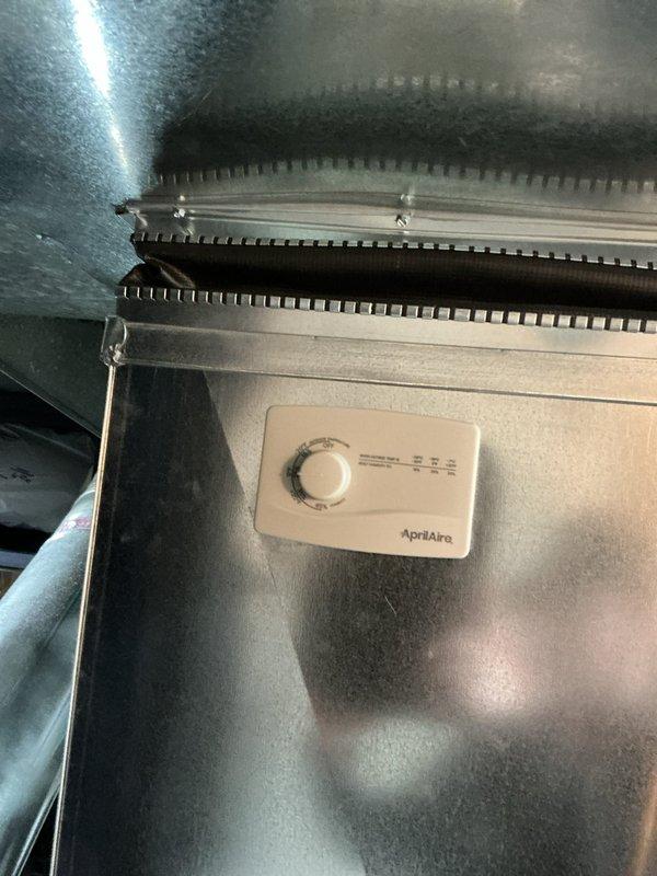 Responded to service call for a 6-month-old furnace with humidifier issues causing increased water bills. Inspected AprilAire humidifier and found evaporative pad heavily contaminated with mold and mineral buildup requiring replacement. Cleaned drainage system to address continuous water flow to laundry tub and adjusted humidistat settings to prevent excessive operation.