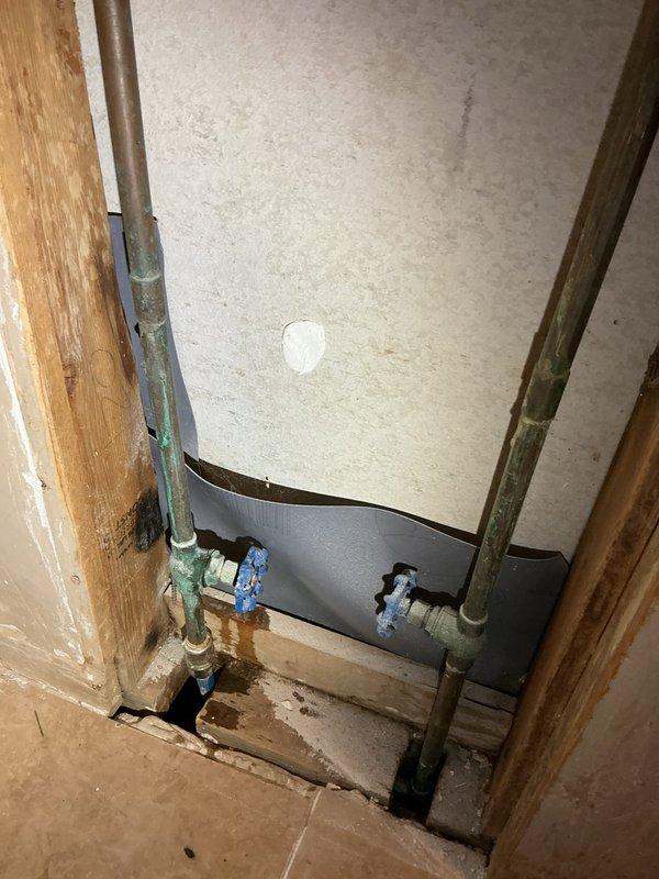 Responded to a basement toilet backup and discovered significant corrosion on copper supply lines with active leaks. Upon inspection, found deteriorating wall panels near the plumbing installation with visible water damage to surrounding wooden floor. Cleared drain blockage, replaced corroded copper pipes, installed new shut-off valves, and applied snake bites to repair leaking sections in both toilet and shower plumbing systems.