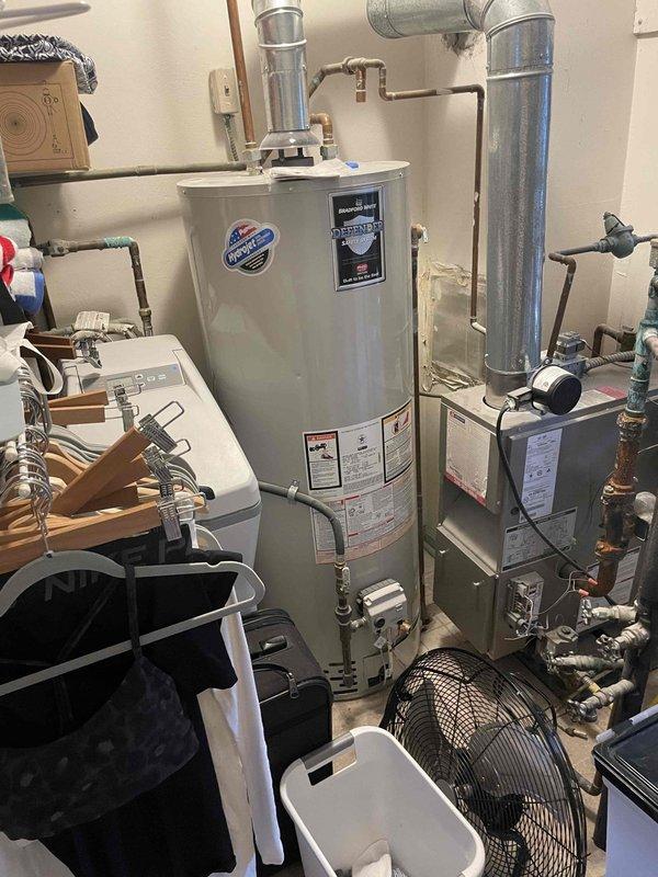 I conducted a comprehensive assessment of the existing boiler system and domestic hot water tank located in the basement. Both units are currently non-operational and will require replacement. Photos were taken of the current installation configuration, including the water heater with its associated ductwork, ventilation components, and plumbing connections to properly spec replacement equipment.