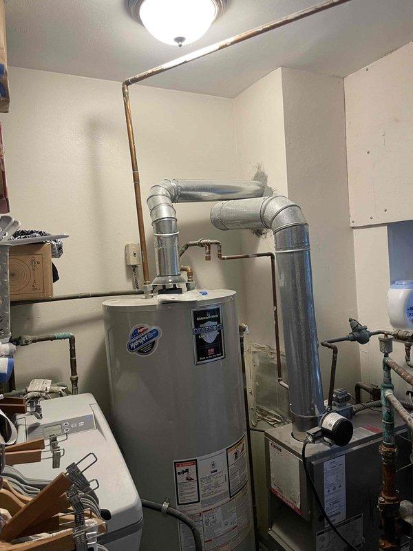 I conducted a comprehensive assessment of the existing boiler system and domestic hot water tank located in the basement. Both units are currently non-operational and will require replacement. Photos were taken of the current installation configuration, including the water heater with its associated ductwork, ventilation components, and plumbing connections to properly spec replacement equipment.