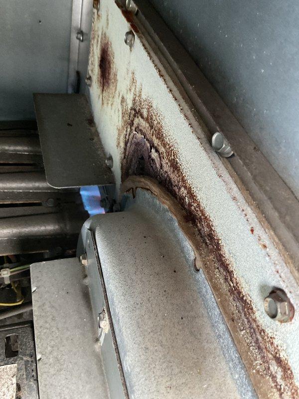 Performed city certification inspection on rooftop package unit. Observed significant rust and corrosion on internal components, particularly on metal panels and heat exchanger surfaces. Unit is installed on proper curb but standing water was noted on roof around equipment, which may be contributing to accelerated deterioration.