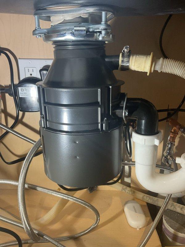 Completed installation of garbage disposal unit beneath kitchen sink, including connection to existing PVC drain system with proper P-trap configuration. Verified all plumbing connections were secure with no leaks, and confirmed proper electrical connection to nearby outlet.