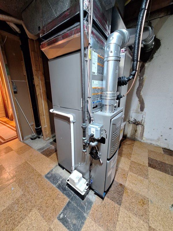 Successfully installed a complete HVAC system consisting of a 70,000 BTU furnace and 2-ton AC unit in basement location. Installation included proper ductwork connections with elbow joints, PVC venting, electrical connections, condensate pump setup, and liner installation. System was fully tested and verified to be operating according to manufacturer specifications.