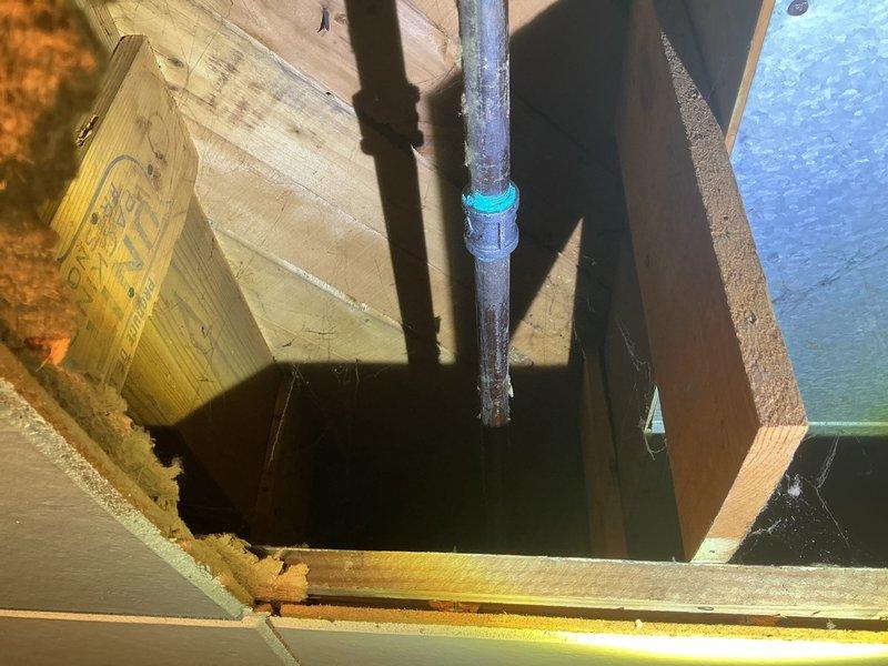 Responded to a callback regarding suspected gas leak at dryer. Inspection confirmed leak in gas line previously serviced, which had already been shut off by DTE. Visual inspection of pipe connections in structural space revealed aging connections with visible cobwebs around pipe joints, particularly at a turquoise connector where the gas line runs through wooden framing.