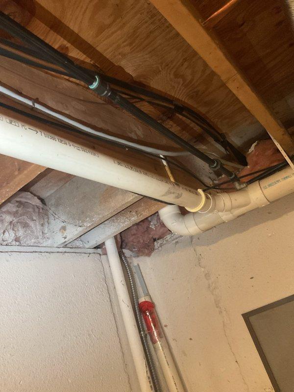 Conducted comprehensive inspection of exposed basement plumbing system, documenting condition of PVC and copper piping installations. Examined connection points, valves, and joint integrity throughout the utility area, with particular attention to the ceiling corner installation where insulation meets plumbing infrastructure. No immediate issues identified in the wooden structural components supporting the plumbing network.