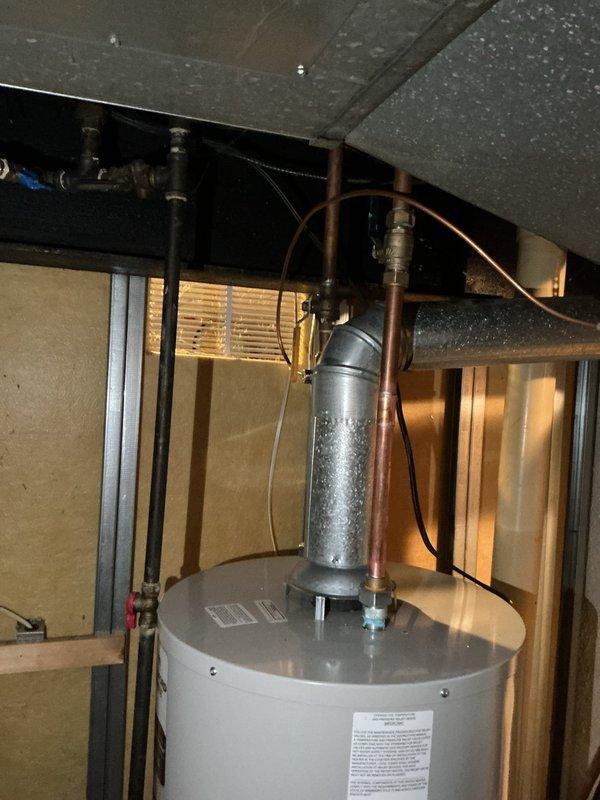 Successfully installed a new 40-gallon tanked water heater in utility area. Installation included proper venting with galvanized metal pipe, connection of copper supply lines, and secure mounting of unit. System was tested and confirmed operational with all connections verified leak-free.