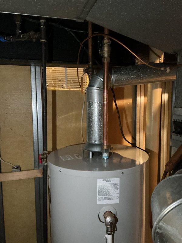 Successfully installed a new 40-gallon tanked water heater in utility area. Installation included proper venting with galvanized metal pipe, connection of copper supply lines, and secure mounting of unit. System was tested and confirmed operational with all connections verified leak-free.