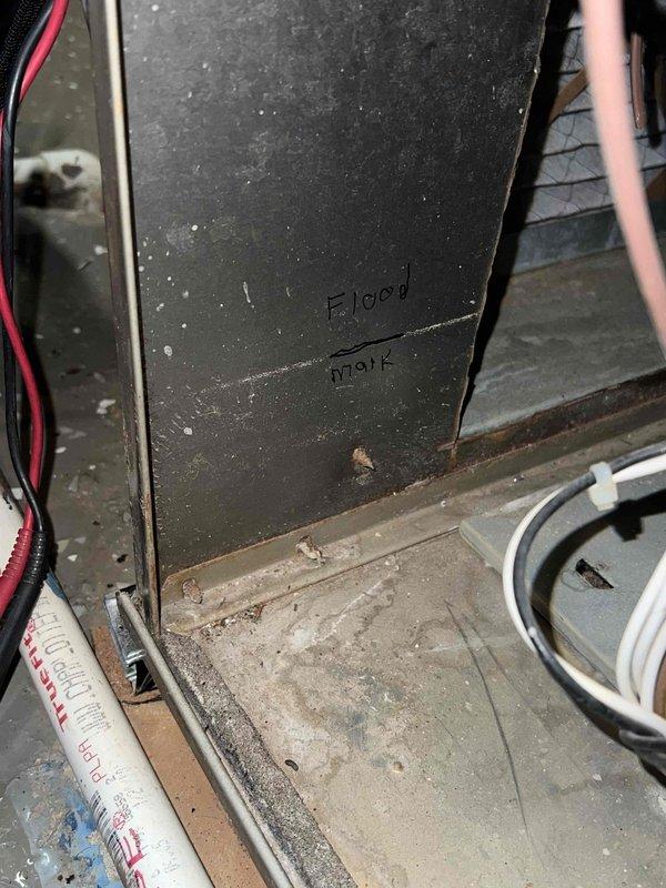 Performed comprehensive tune-up on 12-year-old HVAC system located in basement. Noted previous water damage with visible flood mark on unit exterior. Conducted electrical diagnostics using multimeter, verifying proper voltage readings and electrical connections. System is operational but shows signs of age and previous water exposure.