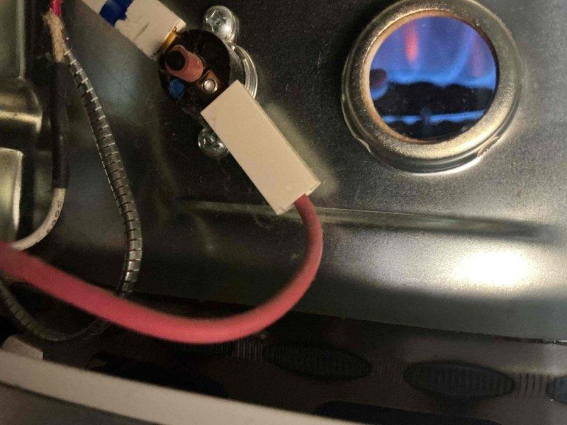 Diagnosed and serviced Bradford water heater experiencing recurring "temperature cut-out limit reached" fault (four red flashes). Performed electrical testing with multimeter, inspected burner assembly and flame pattern, and verified proper ignition component function. Reset system after confirming normal operation parameters and proper combustion.