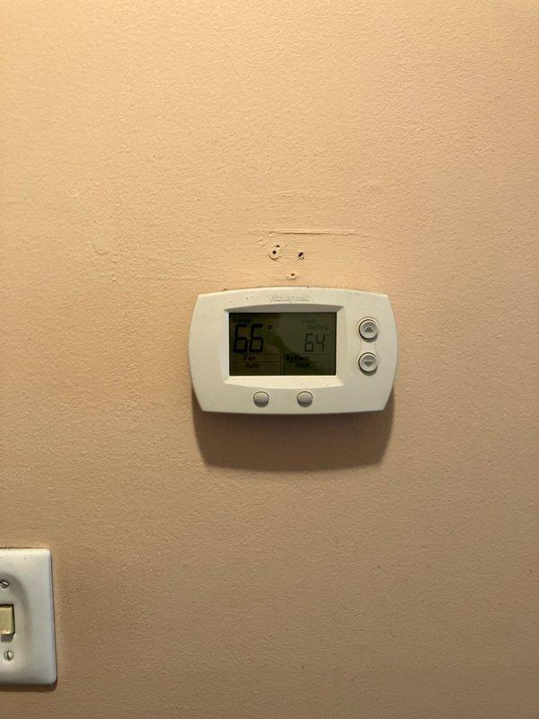 Conducted assessment for new AC installation in residence with existing 10-year-old gas furnace located in basement. Documented current Honeywell thermostat showing 65°F/64% humidity readings and inspected existing water heater setup with proper venting. Prepared comprehensive replacement estimate for AC-only installation based on site evaluation.