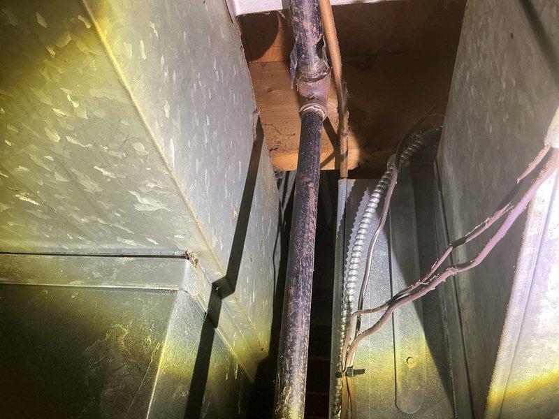 Conducted gas leak inspection in basement utility area where customer needed fitting for dryer connection. Performed pressure test on existing gas lines, inspecting corroded copper piping and connections running through joists. Identified and repaired leak point at flexible metal conduit junction, ensuring system integrity before connecting dryer appliance.