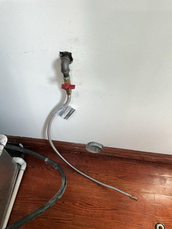 Installed a new gas line with proper shutoff valve for customer's appliance. Connected flexible stainless steel connector to existing gas pipe, ensuring secure mounting to wall and appropriate penetration through wooden floor surface. All connections were tested for leaks after installation to verify safe operation.