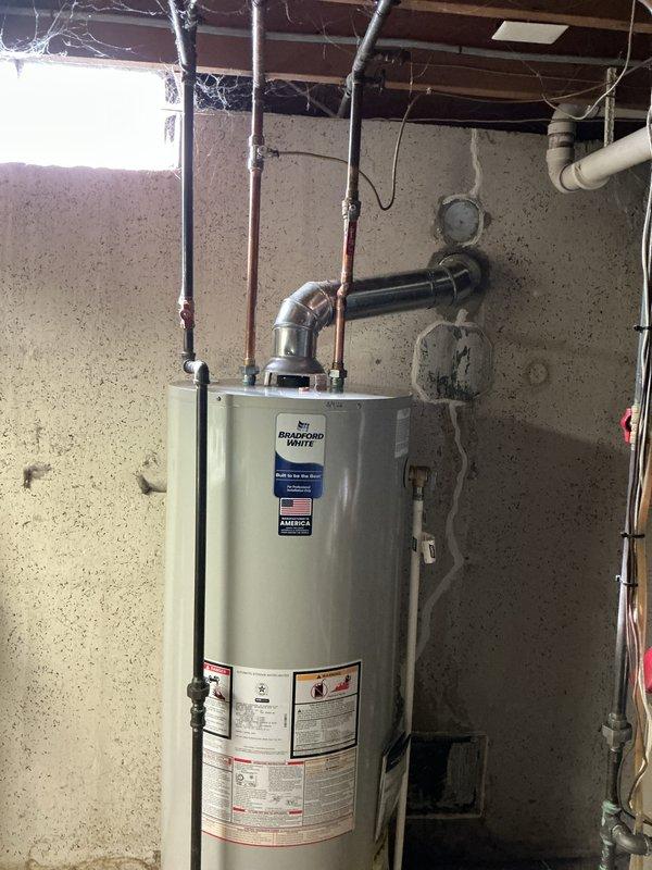 Successfully installed a 50-gallon natural draft gas water heater in basement utility area. Completed all necessary plumbing connections including copper supply lines, metal exhaust vent/flue with proper elbow joint configuration, and verified proper ventilation. Customer payment processed via credit card.