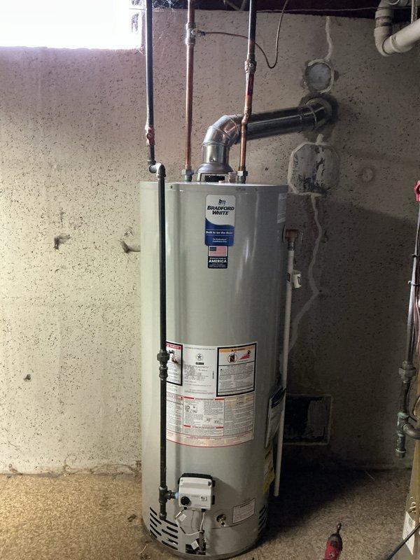 Successfully installed a 50-gallon natural draft gas water heater in basement utility area. Completed all necessary plumbing connections including copper supply lines, metal exhaust vent/flue with proper elbow joint configuration, and verified proper ventilation. Customer payment processed via credit card.