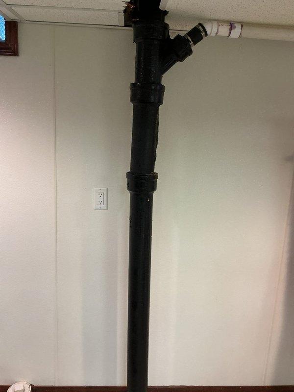 Responded to service call for waste pipe issue in 98-year-old home. Inspected plumbing infrastructure in basement where problem had been gradually developing. Identified and cleared blockage in the drainage system, verifying proper flow through the main vertical PVC pipe and its Y-junction connections to ensure full functionality of the waste pipe system.