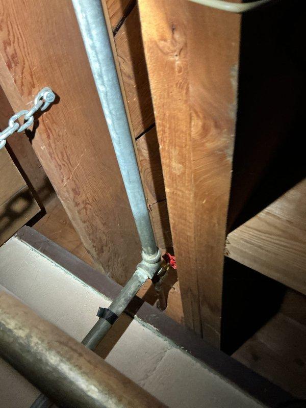 Diagnosed and repaired a leaking shower in a 1960s home by accessing the plumbing through the wall cavity to inspect the galvanized steel piping and valve assembly. Identified deterioration at the valve connection point as the source of the leak and replaced the affected components, restoring proper function to the first-floor shower fixture.