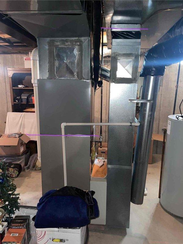 Performed diagnostic inspection of 22-year-old basement furnace that was blowing cold air, confirming DTE's assessment that replacement is necessary. Visual inspection revealed aging components and inefficient operation of the existing unit, which is connected to standard metal ductwork and PVC ventilation system. Documented current thermostat (showing 68°F) for compatibility considerations with replacement system.