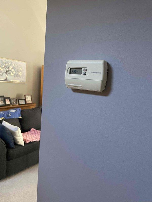 Performed diagnostic inspection of 22-year-old basement furnace that was blowing cold air, confirming DTE's assessment that replacement is necessary. Visual inspection revealed aging components and inefficient operation of the existing unit, which is connected to standard metal ductwork and PVC ventilation system. Documented current thermostat (showing 68°F) for compatibility considerations with replacement system.