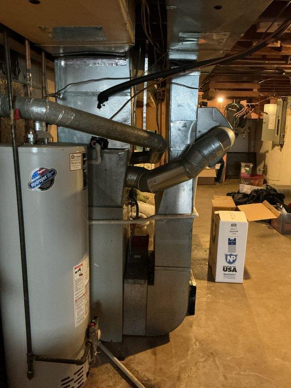 Performed a furnace inspection on a 10+ year old unit located in the basement, confirming tech lead's finding of a cracked heat exchanger. System consists of a main furnace unit with connected sheet metal ductwork and PVC venting. Replacement is recommended due to safety concerns with the compromised heat exchanger.