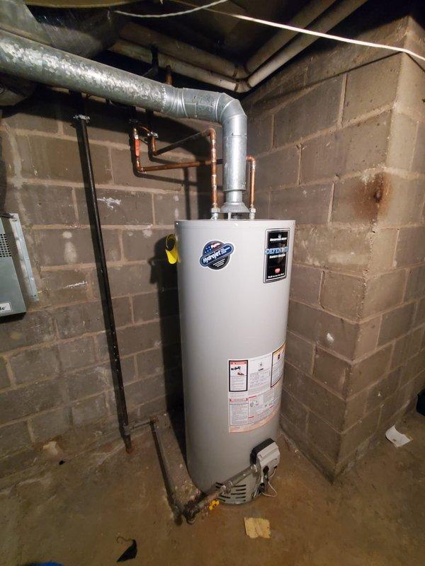 Completed Gold Boiler Inspection on 1-year-old hot water boiler system and furnace in basement. Visual inspection revealed proper flame pattern with characteristic blue flames in the furnace burners. Water heater appears properly installed with appropriate venting and copper supply lines connected to the system.