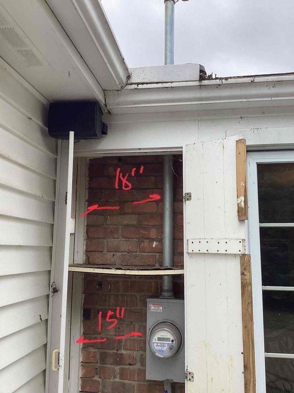 Performed comprehensive generator estimate at residential property, documenting existing HVAC installation with visible refrigerant lines along brick exterior and electrical utility access points. Noted measurement markings (15"-16") on brick wall near electrical meter that will be relevant for generator placement and connection to home's electrical system.