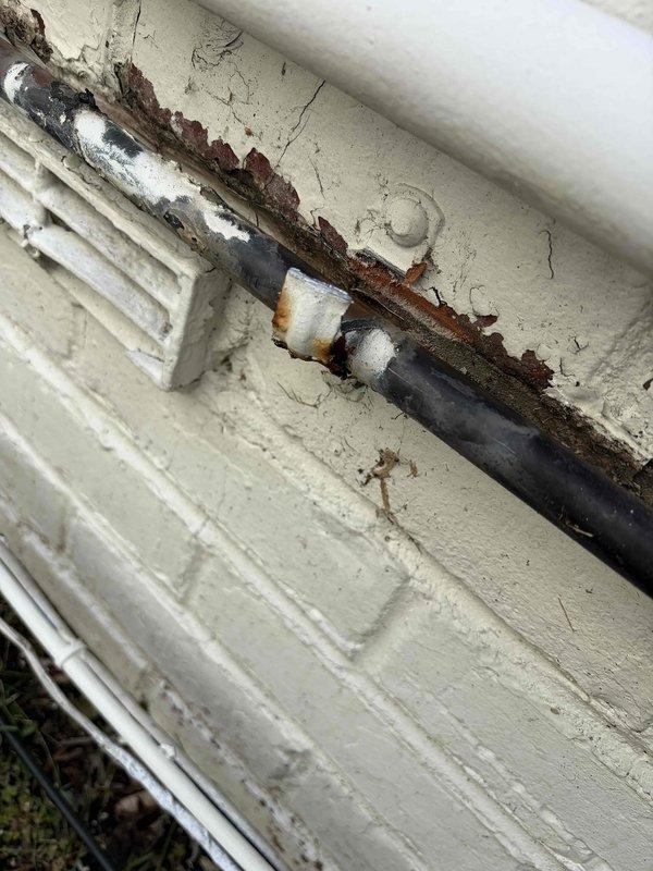 Completed insulation of outdoor line set per warranty requirements. Addressed corrosion issues on exterior piping and ensured proper sealing against the building's exterior wall. Photographic documentation taken of completed work showing the properly insulated line set installation.