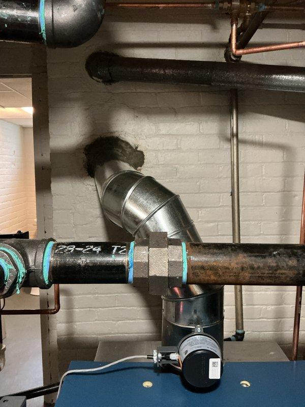 Successfully completed installation of new boiler system with proper plumbing connections. Installed black insulated piping with appropriate fittings and valves, connecting to existing mechanical infrastructure. System was properly mounted against basement wall with all necessary gauges and control mechanisms in place.