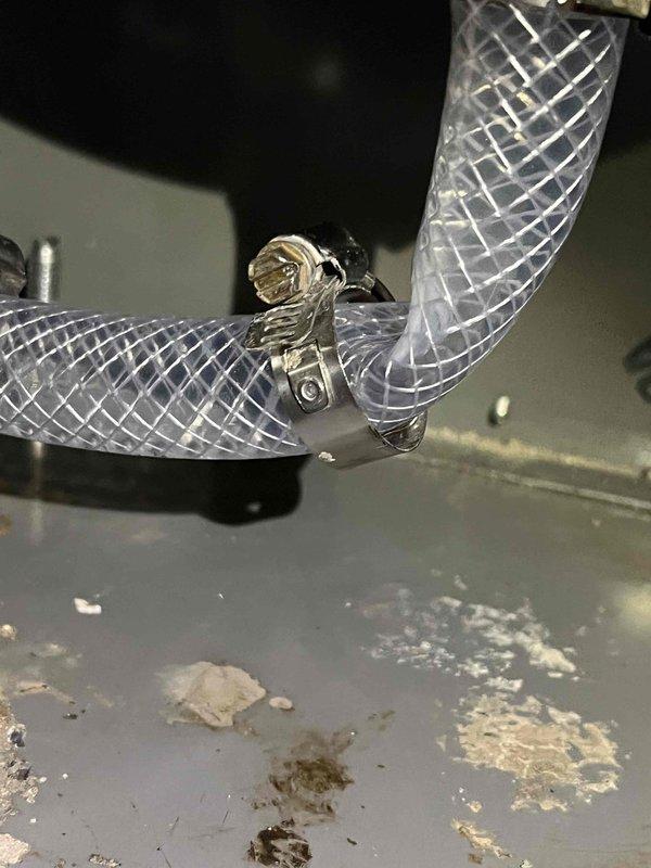 Performed routine heating maintenance tune-up on 19-year-old system. Identified and repaired leaking condensate trap, replacing deteriorated plastic tubing with new reinforced tubing secured with stainless steel clamps. System is now functioning properly with no leaks observed.