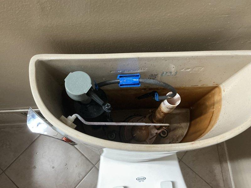 Inspected toilet in master bathroom that was reported as not filling properly. Upon examination, observed mineral buildup and scale on internal tank components, particularly affecting the fill valve mechanism. Disassembled, cleaned, and adjusted the float assembly and flush valve to restore proper water flow and tank filling function. Confirmed toilet now operates correctly with appropriate water levels and complete flush cycle.