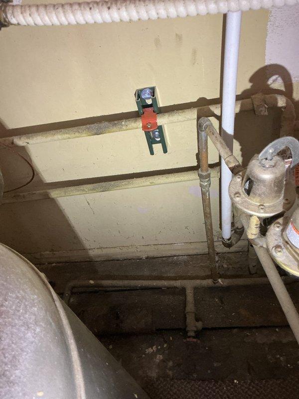 Installed new copper piping with brass fittings on Lochinvar water heater system, addressing corrosion at connection points. Secured installation using ceiling-mounted bracket system with proper support hardware for the plumbing configuration.