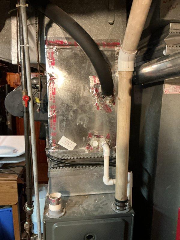 Performed inspection of existing natural gas furnace system in basement, which is over 10 years old but currently operational. Documented current installation configuration including ductwork, PVC venting/drainage pipes, and connection points. Provided replacement estimate for aging furnace system with detailed documentation of existing plumbing infrastructure and electrical connections necessary for proper equipment installation.