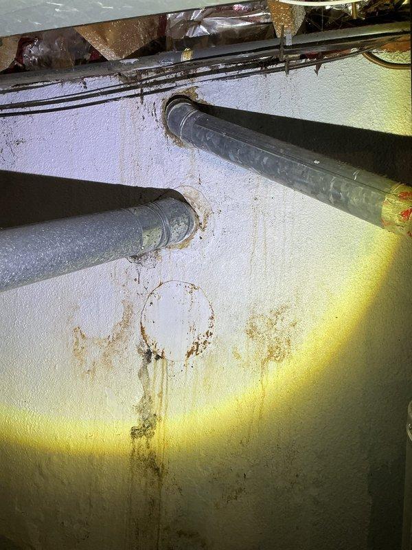 Diagnosed and serviced Performance brand water heater with thermopile voltage issues causing interrupted hot water supply throughout residence. Inspected unit in basement, noting significant water damage and staining on adjacent wall indicating possible previous leaks. Replaced defective thermopile component to restore proper functionality and ensure consistent hot water delivery.