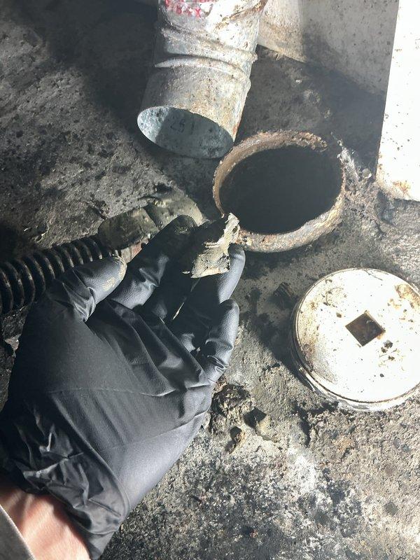 Responded to service call for a clogged drain in basement laundry area that had been problematic for approximately 5 days. Upon inspection, removed floor drain cleanout access cap and identified significant buildup of debris restricting water flow. Successfully cleared the blockage using appropriate snaking equipment, restored proper drainage function, and documented the condition with photos before and during service.