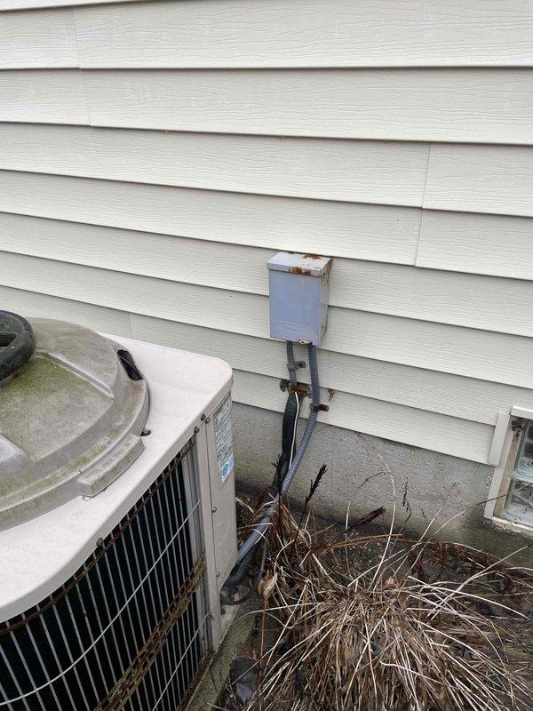 Conducted inspection of existing 10+ year old furnace and air conditioning system located in basement with natural gas fuel source. Exterior assessment revealed aging outdoor AC unit with weathering on electrical junction box and debris accumulation near foundation. Documented current electrical service configuration including dual meters and associated distribution equipment to evaluate capacity for potential HVAC replacement options.