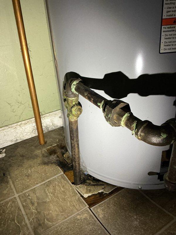 Responded to service call for a 3-4 year old water heater leaking from the bottom in the laundry room. Upon inspection, confirmed tank failure with visible corrosion at base connections and significant mineral buildup around pipe joints. Determined water heater requires replacement due to internal tank rupture, which is not repairable.
