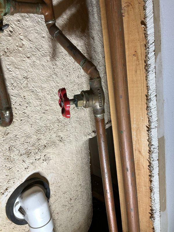 Responded to a water leak service call in the basement where copper supply lines were showing signs of corrosion with green patina at connection points. Upon inspection, identified moisture damage to adjacent wooden framing and installed a new shut-off valve with red handle to isolate the affected section of plumbing. Completed repairs to prevent further water damage and ensure proper system functionality.