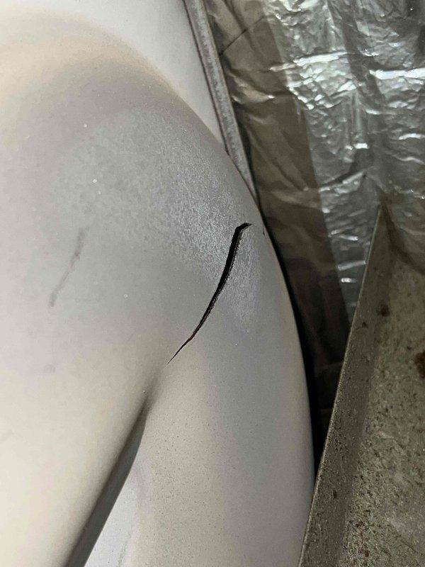Responded to no-heat call for 32-year-old Lennox furnace with burning odor. Diagnosed cracked heat exchanger causing system failure, evidenced by visible fracture in combustion chamber and confirmed through visual inspection. Due to age of unit and safety concerns, recommended complete system replacement as repair not viable.