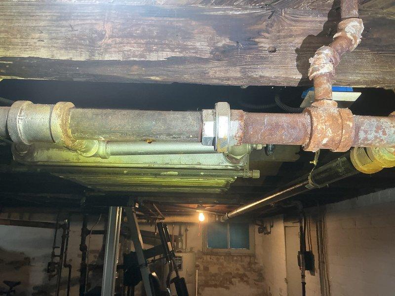 Replaced severely corroded steam line segments in basement utility area, focusing on sections with extensive rust damage and failing joints. Installed new pipe fittings with proper thread sealant at connection points and tested system to ensure proper steam distribution without leakage.