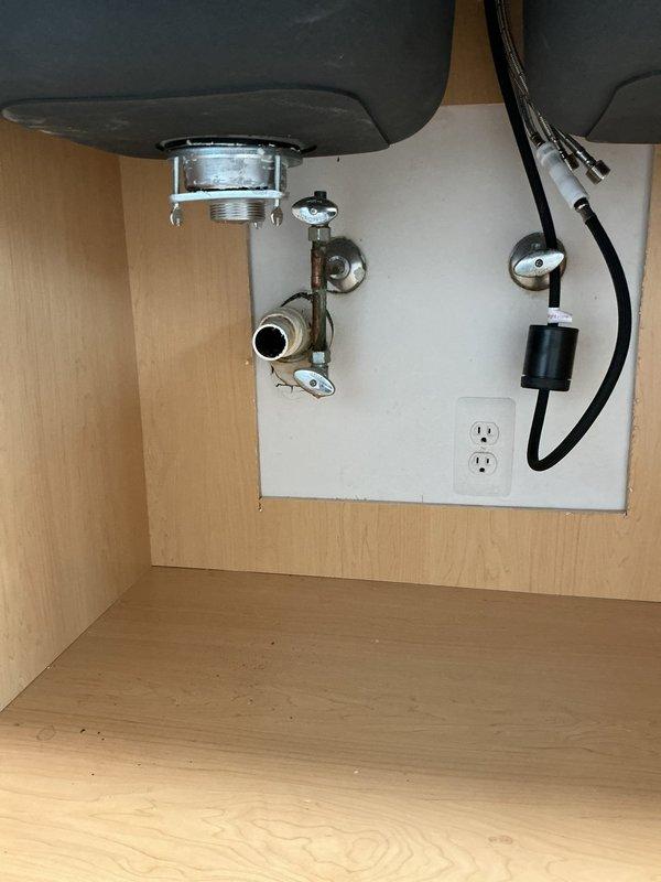 Performed diagnostic assessment of kitchen sink plumbing system requiring complete assembly. Examined disconnected PVC components and existing metal drain assembly with P-trap configuration. Determined requirements for proper installation of sink drain, P-trap connection, and potential dishwasher hookup. Documented current state with photos showing partially installed components and provided detailed estimate for completing the plumbing installation.