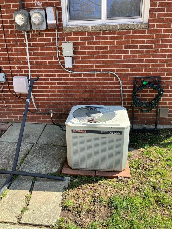 Inspected 32-year-old G23 furnace which had completely stopped working and was emitting a burning odor. Discovered large crack in heat exchanger requiring full system replacement. Provided customer with three replacement options: furnace only, furnace/AC combination, or complete system with furnace, AC and water heater. Noted customer's interest in tankless water heater due to space constraints and possible APCO/i-wave air purification system. Documented existing Trane XE 900 outdoor unit and challenging installation access in basement location.